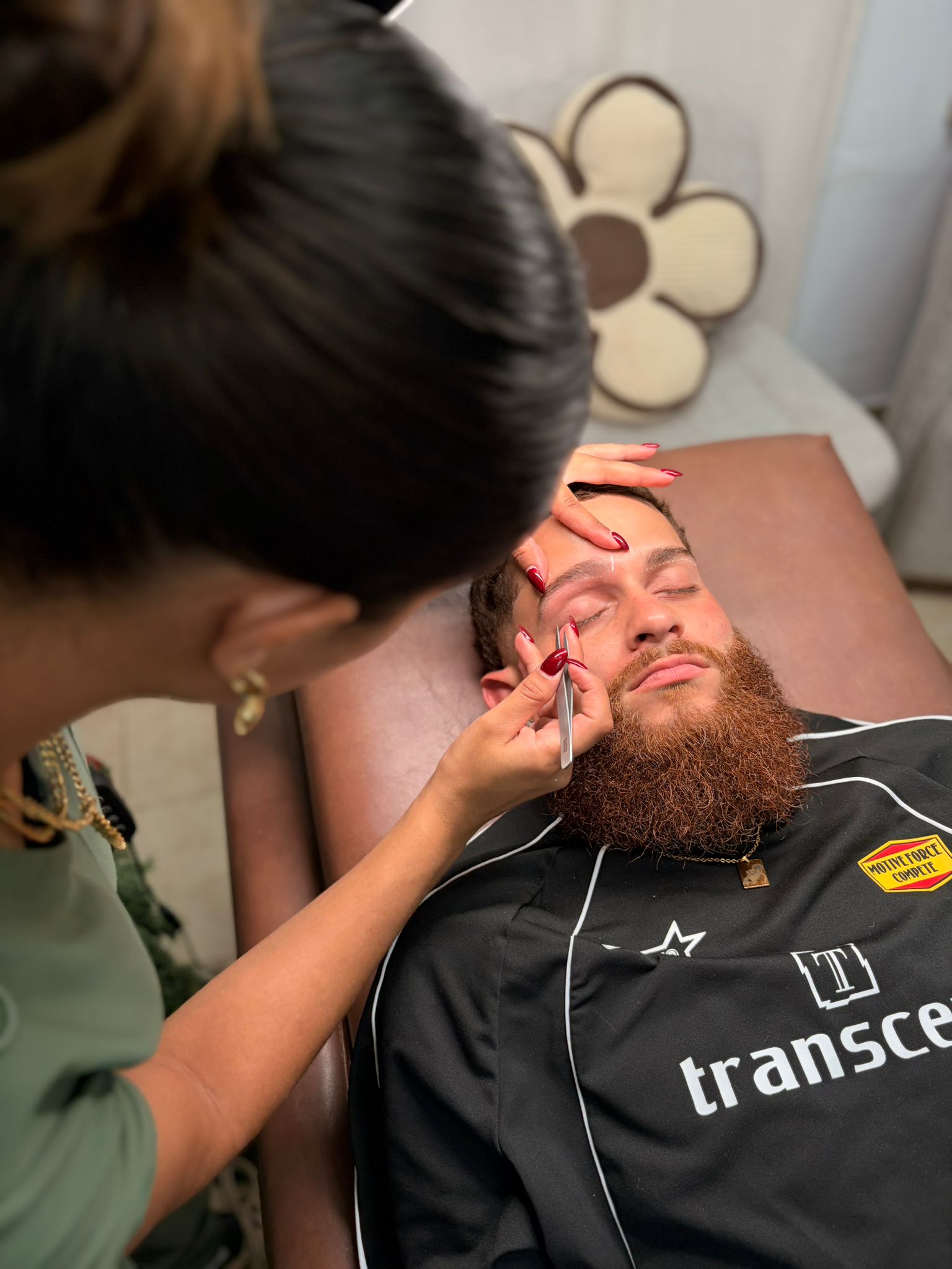 Leudy diseñando las cejas de una cliente durante un tratamiento